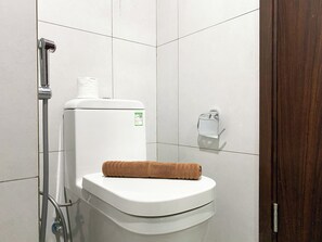 Ein modernes Badezimmer mit Toilette, Handtuchhalter und Handtrockner.
