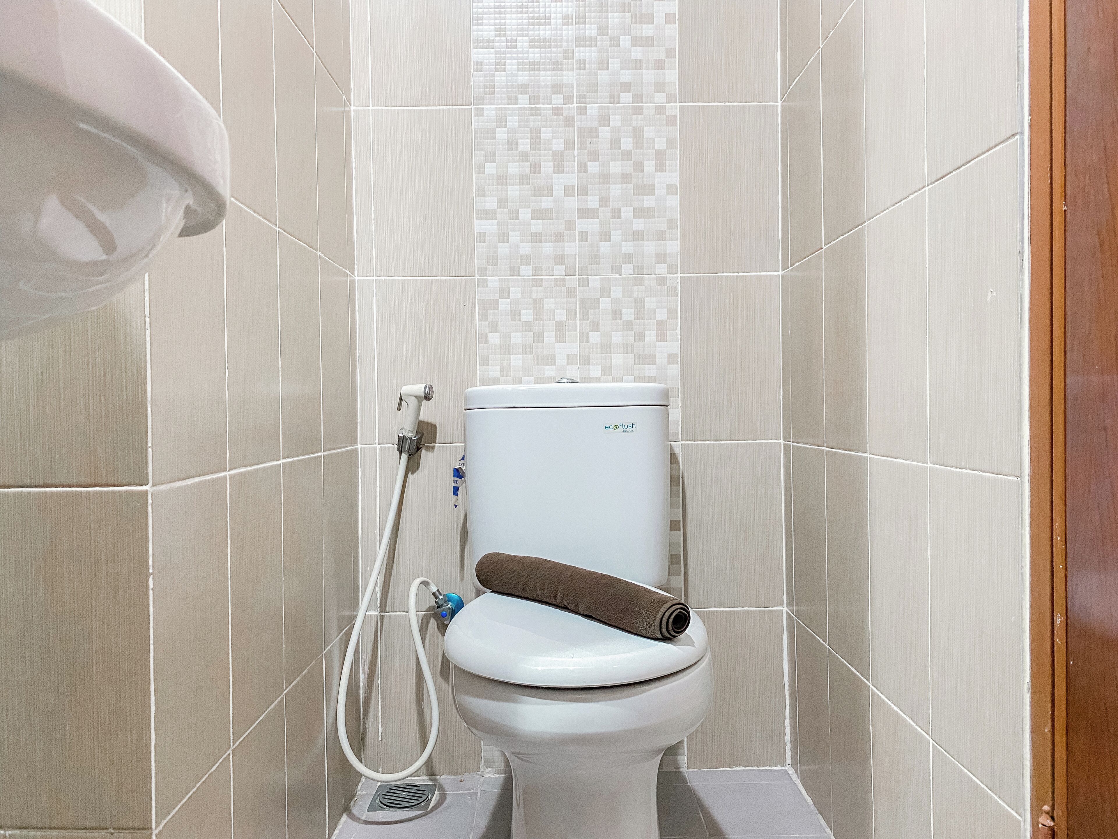 Ein Badezimmer mit Toilette, Dusche und gefliesten Wänden.