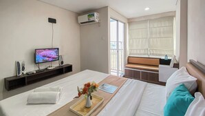 Une chambre d’hôtel équipée d’un lit, d’une télévision, d’une fenêtre avec vue et d’un appareil de climatisation.