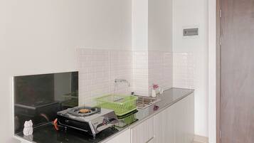 Standaard appartement | Privékeuken | Een koelkast, kookgerei, borden en bestek