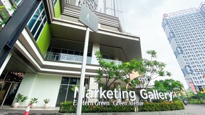 A modern building with a pedestrian crossing sign, surrounded by greenery and other high-rise buildings.