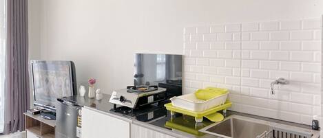 A modern kitchen with a built-in stove, a sink, and a flat-screen TV.