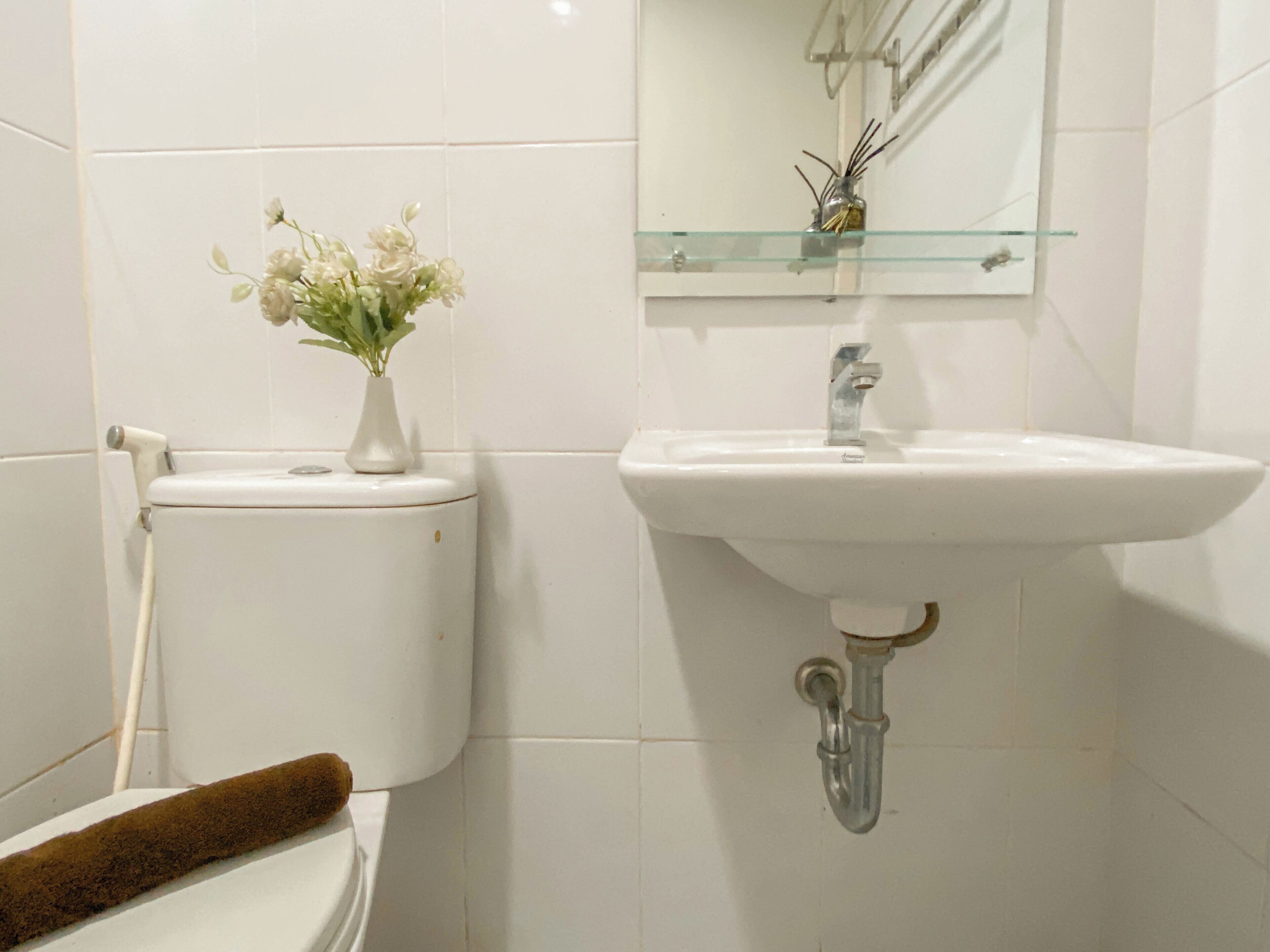 Ein Badezimmer mit Toilette, Waschbecken und Spiegel.