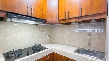 Standaard appartement | Privékeuken | Een koelkast, kookgerei, borden en bestek