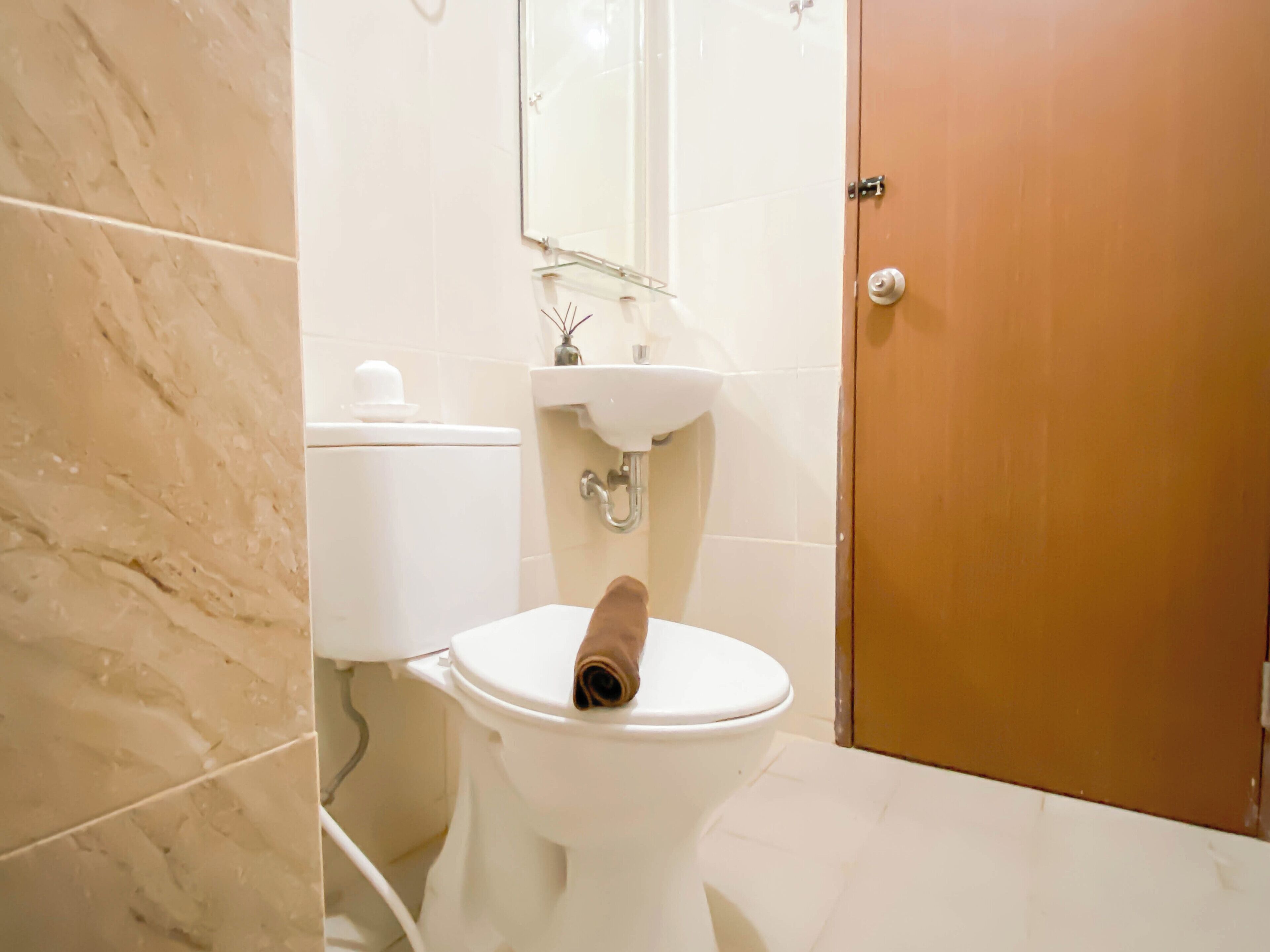 Un bagno con il water, un lavandino e uno specchio.