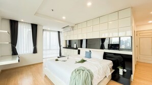 A modern hotel room with a large bed, a TV, and a city view. - Spacious Luxury 2Br Apartment With Extra Room At Fx Residence (Jakarta)