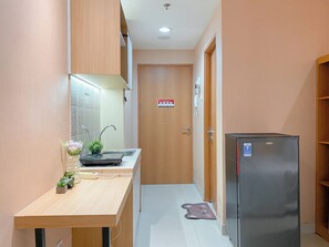 Standard Apartment | Private kitchen | Fridge, cookware/dishes/utensils - Peach Tone Studio At Evenciio Margonda Apartment (Depok)