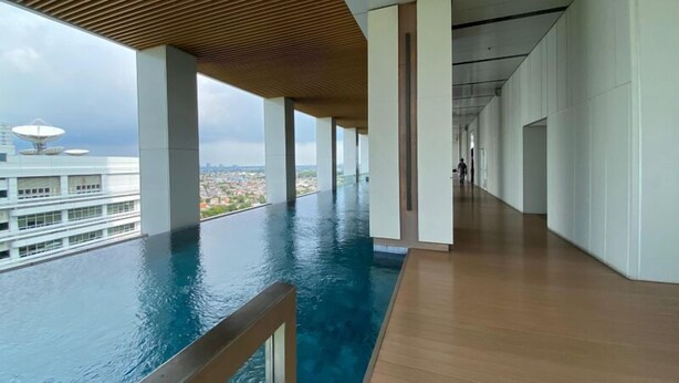 En modern inomhuspool med utsikt över stadssiluetten.