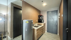 Standaard appartement | Privékeuken | Een koelkast, kookgerei, borden en bestek