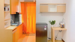 Une cuisine compacte avec des meubles en bois, une cuisinière encastrée et un petit réfrigérateur.