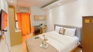Une chambre d’hôtel équipée d’un lit, d’un bureau, d’une télévision et d’un appareil de climatisation.