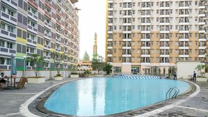 A swimming pool surrounded by multi-story residential buildings with balconies.