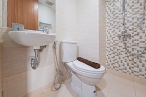 A bathroom with a white sink, toilet, and shower. - Studio Near Krl Station At Cisauk Point Apartment (Cisauk)