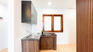 Una cocina moderna con encimera de madera, un lavaplatos empotrado y una ventana con marcos de madera.