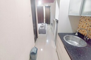 Standaard appartement | Privékeuken | Een koelkast, kookgerei, borden en bestek