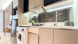 Una cocina moderna con lavadora integrada, un lavabo y una estufa.