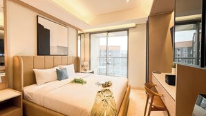 Una habitación de hotel moderna con una cama grande, un escritorio y un balcón con vistas a la ciudad.