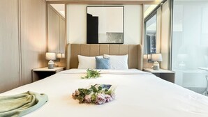 Una habitación de hotel con una cama grande, dos mesitas de noche con lámparas, un cabecero y una ventana con vistas.