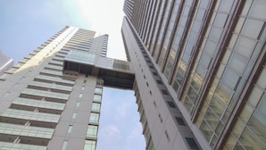 A high-rise building with a modern architectural design, featuring multiple floors and a prominent glass facade. - Strategic Place 2Br Apartment With Private Lift Masterpiece The Epicentrum Kuningan (Jakarta)