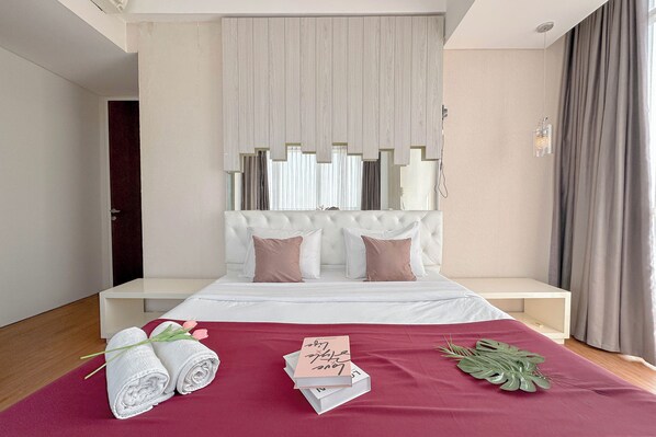 A modern hotel room with a bed, a bedside table, and a large window with curtains. - Modern Minimalist 2Br At Linden Apartment (Surabaya)