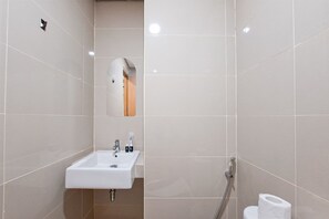 Une salle de bain avec un lavabo, un miroir et des toilettes.
