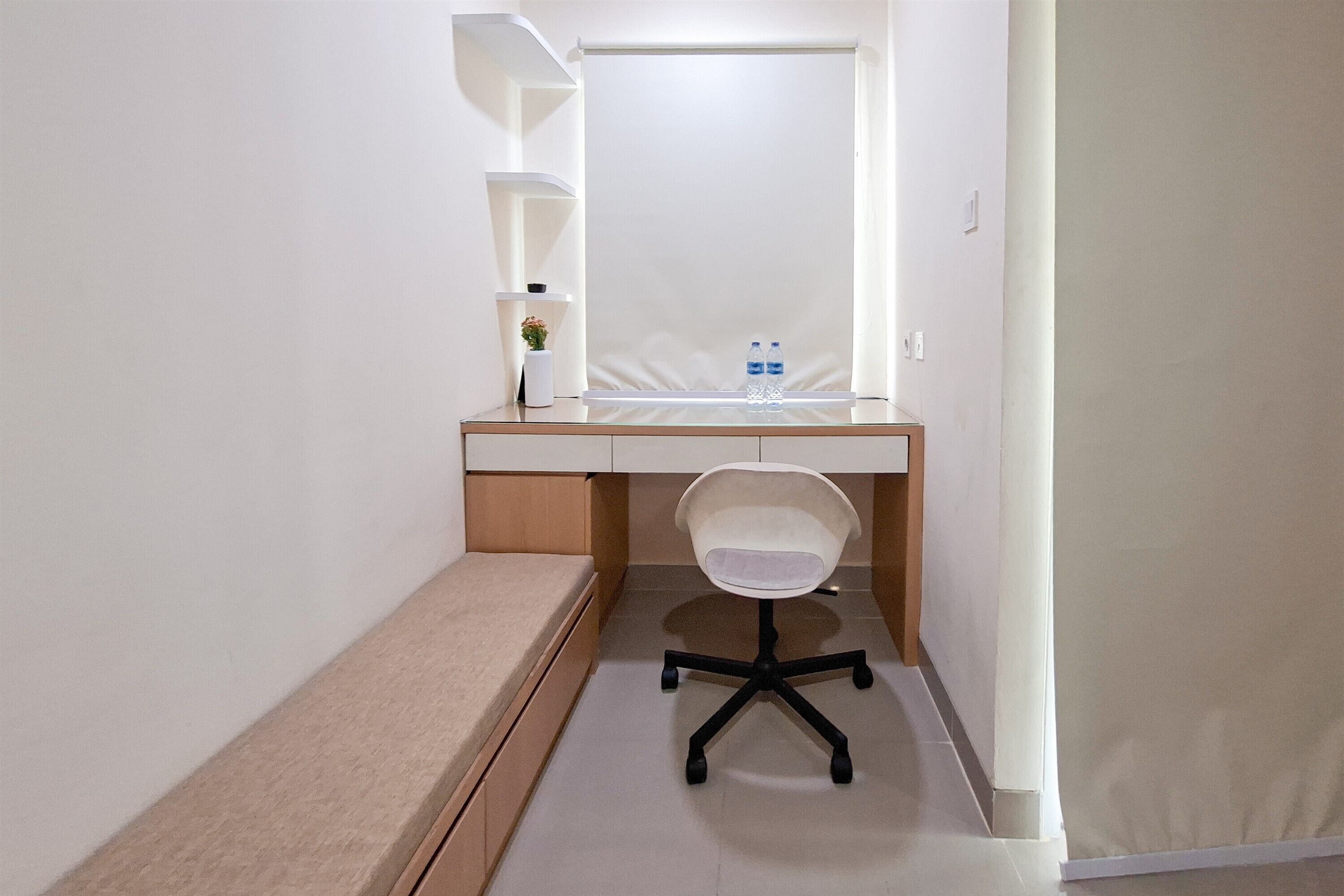 A small, modern bathroom with a white sink, a mirror, and a chair.