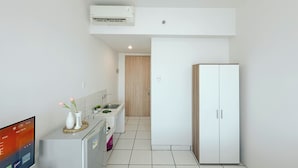 A modern kitchen with a built-in air conditioner, a refrigerator, and a sink. - Simple Style Studio At The City Square Surabaya Apartment (Surabaya)