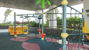 A playground with climbing structures and a slide, surrounded by greenery. - Modern Studio Near Taman Ismail Marzuki At Apartment Menteng Park (Jakarta)