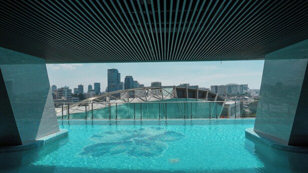 A rooftop pool with a city skyline view, including a bridge and high-rise buildings. - Modern Studio Near Taman Ismail Marzuki At Apartment Menteng Park (Jakarta)