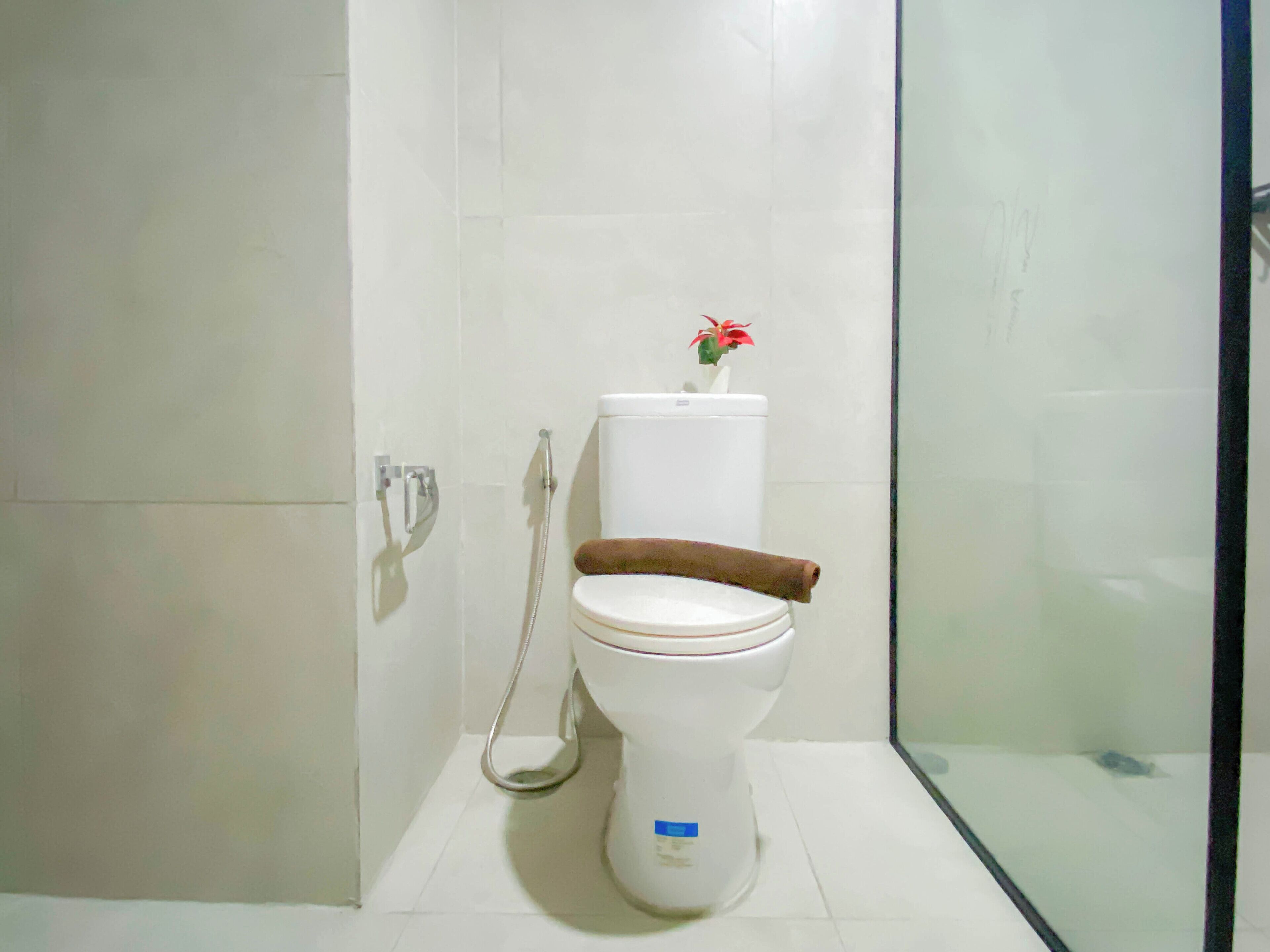 A modern bathroom with a toilet, a shower, and a glass shower enclosure.