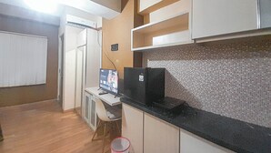 Une cuisine compacte équipée d’un réfrigérateur, d’un four à micro-ondes et d’un petit coin repas.