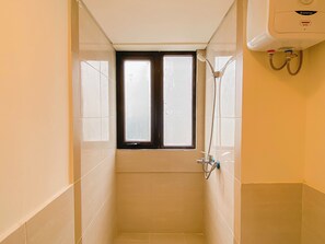 Ein kleines, schmales Duschbad mit Fenster und Wandheizung.