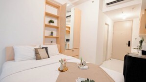 A modern bedroom with a bed, bedside tables, a mirror, and a wardrobe. - Basic Look Studio (No Kitchen) Apartment Tokyo Riverside Pik 2 (Teluknaga)