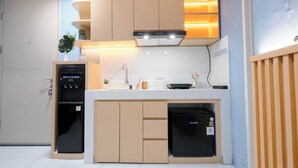 A modern kitchen with built-in appliances, a central island, and a wooden accent wall.