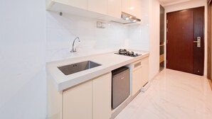 A modern kitchen with white cabinetry, a stainless steel sink, and a built-in dishwasher.