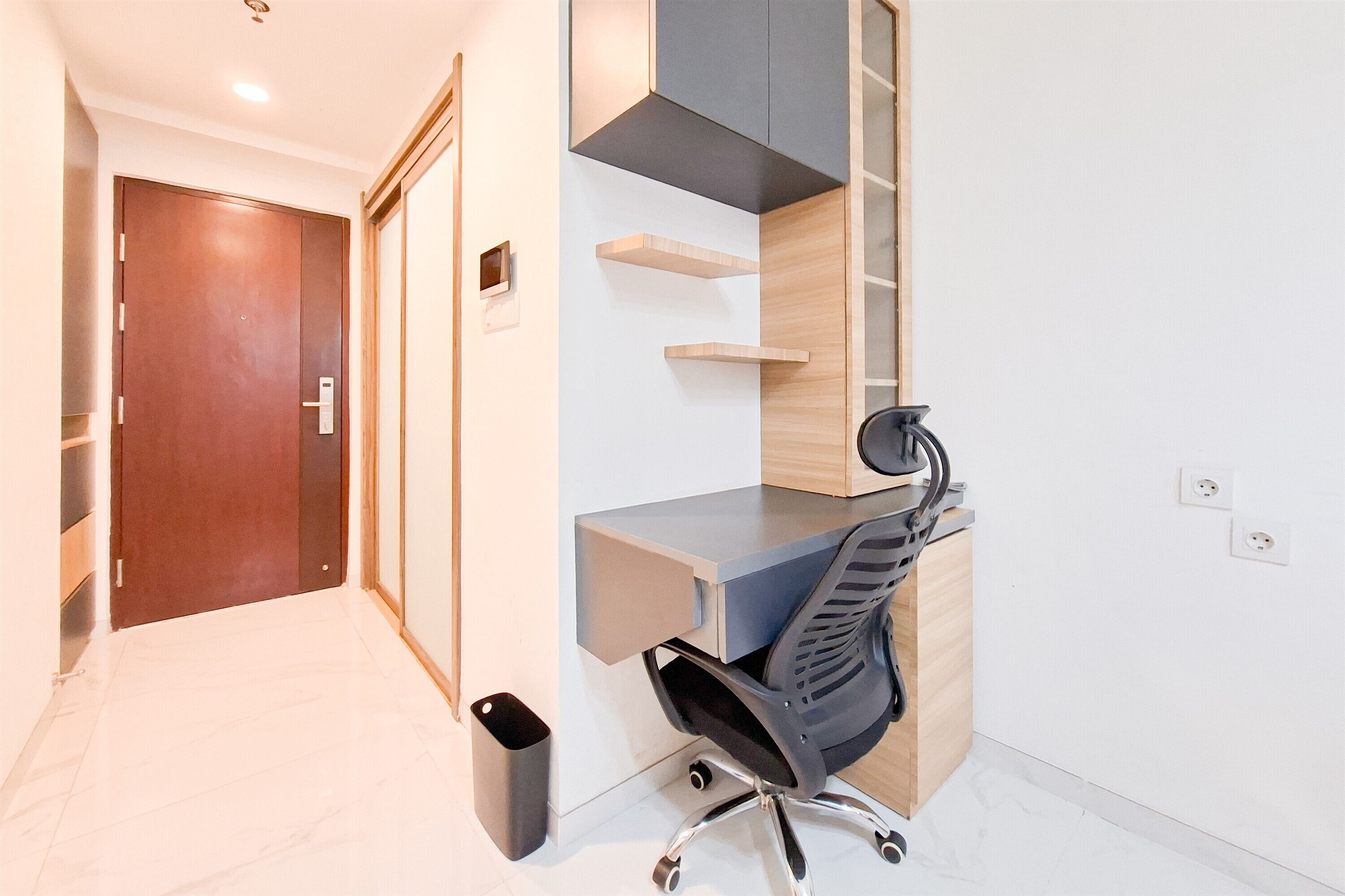 A modern office space with a desk, chair, and shelving units.