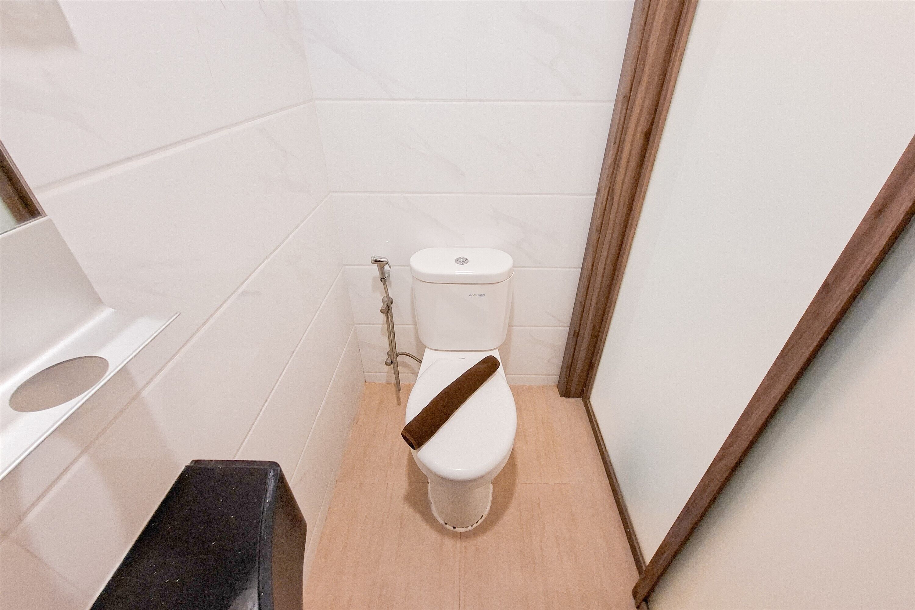 A small, modern bathroom with a toilet, a sink, and a shower area.