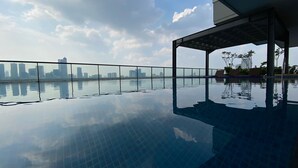 A rooftop infinity pool with a city skyline view. - Warm Contemporary 2Br Apartment At Samara Suites (Jakarta)