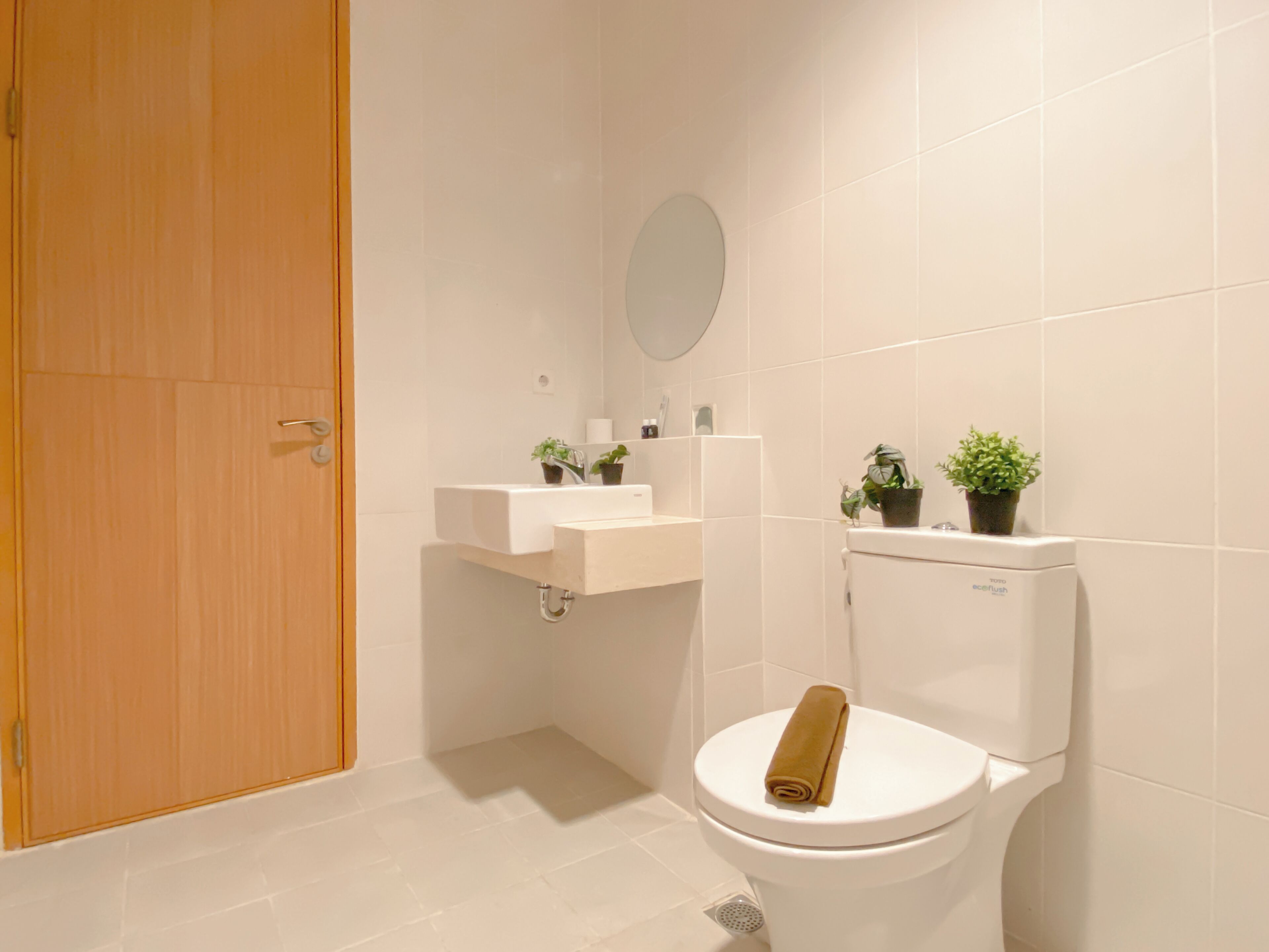A bathroom with a toilet, sink, and mirror.