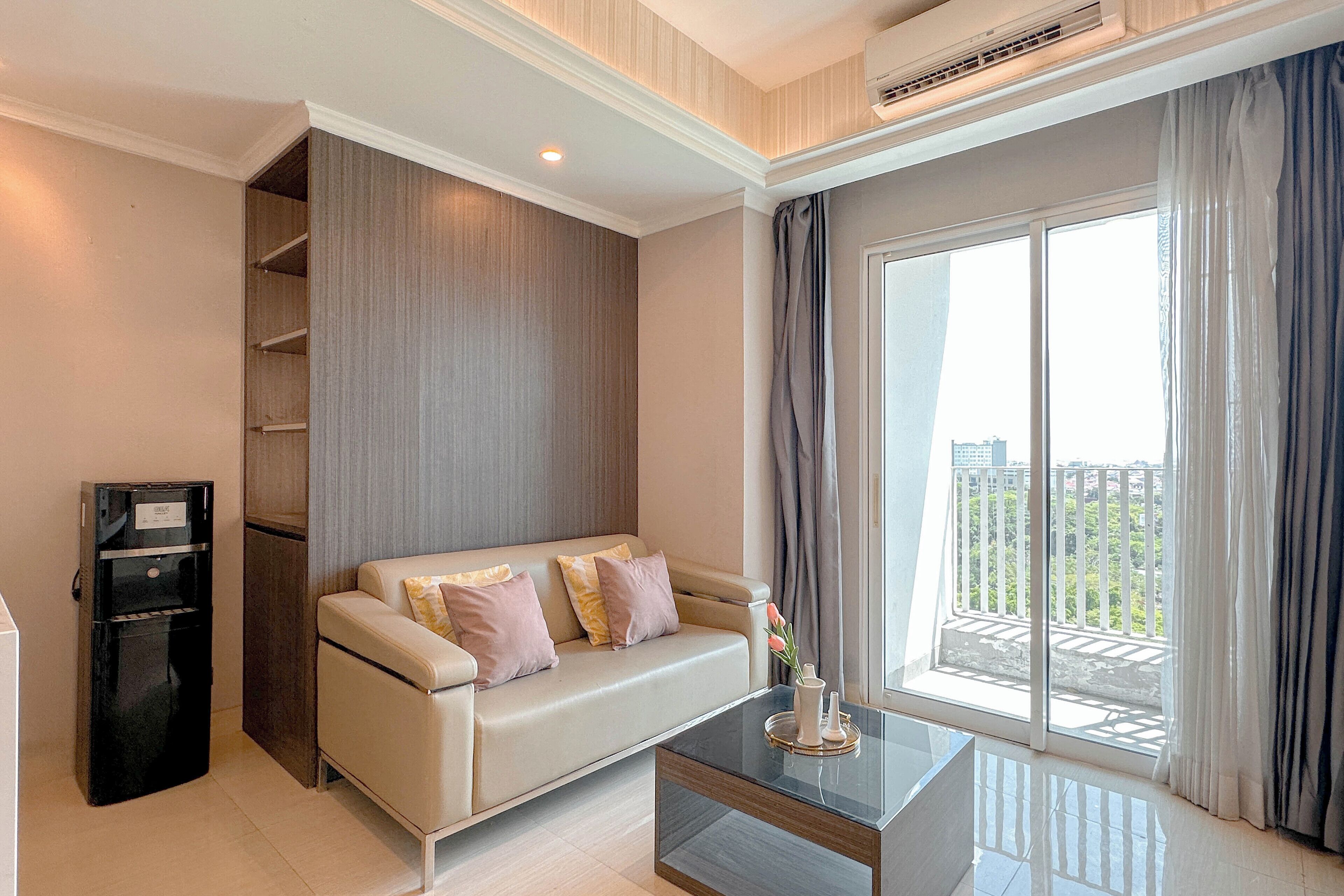 A modern living room with a sofa, a coffee table, and a built-in air conditioning unit.
