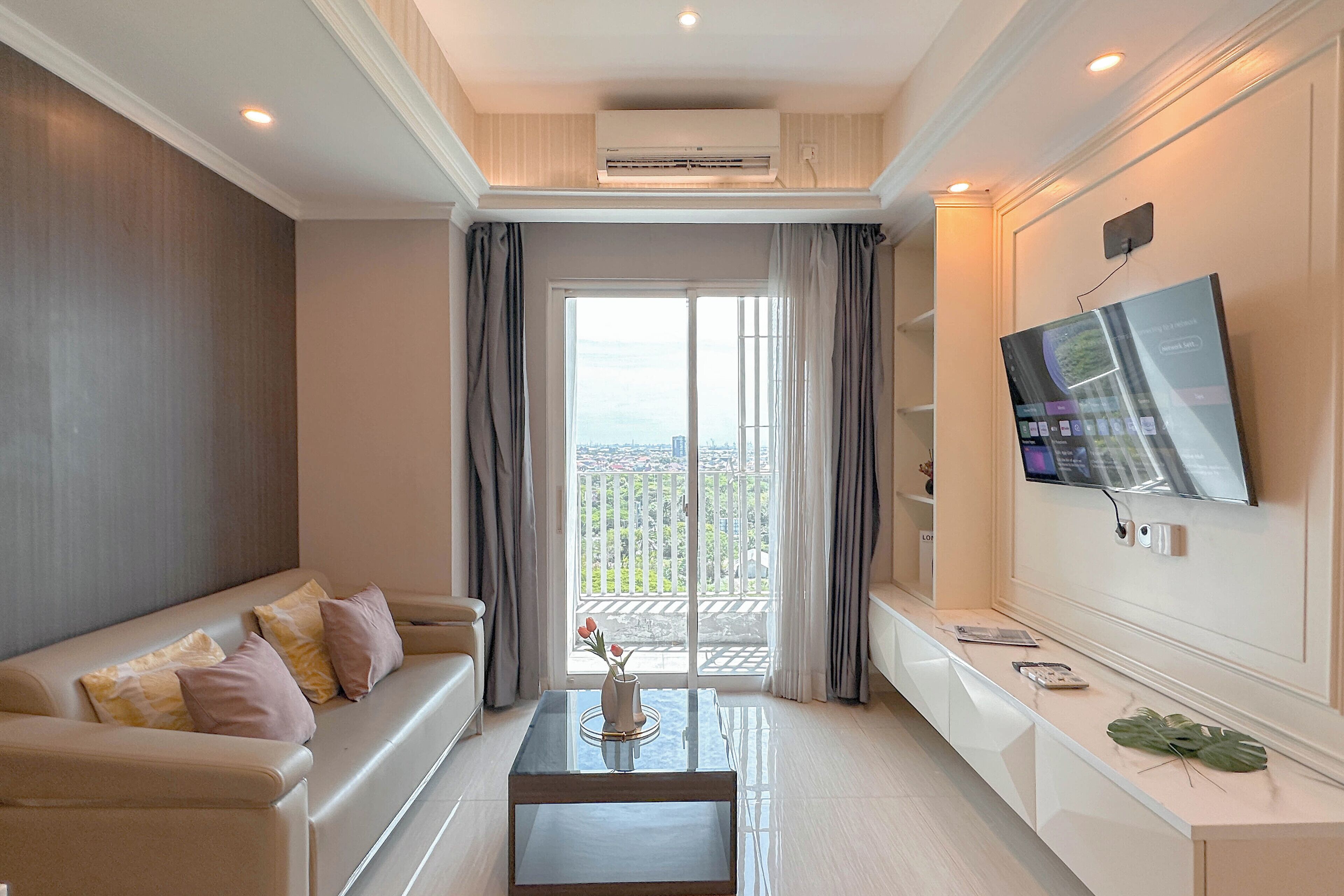 A modern living room with a sofa, coffee table, and a TV mounted on the wall.