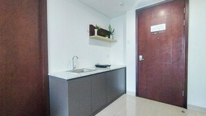 A kitchen with a sink, cabinets, and a wooden door.