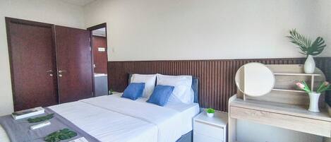 Un dormitorio con cama, mesita de noche y escritorio con silla.