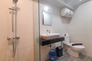 A bathroom with a glass-enclosed shower, a white sink, a toilet, and a wall-mounted air purifier. - Cozy Loft 2Br At Grand Jati Junction Apartment (Medan)