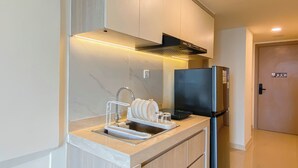 Een moderne keuken met een inbouwspoelbak, roestvrijstalen apparatuur en een compacte indeling.