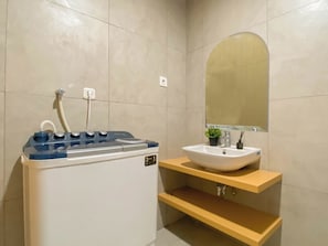 A bathroom with a white sink, a mirror, and a shower with a control panel.