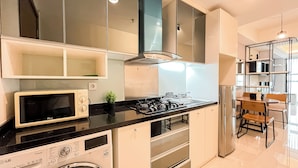 Una cocina moderna con microondas, estufa, horno y una lavadora-secadora compacta.