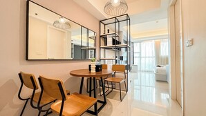 Un comedor moderno con una mesa redonda, sillas de madera y un espejo grande.