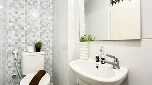 Un baño con inodoro, lavabo y espejo.