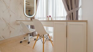 Une salle de bain moderne avec un mur en marbre, un meuble-lavabo blanc avec un miroir, une chaise blanche et une fenêtre avec des rideaux.